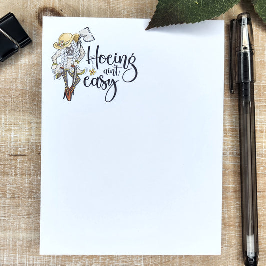 girl gnome in braids, floppy hat, and heals. She is holding a garden hoe. Words 'Hoeing Ain't Easy" accompany the pictures